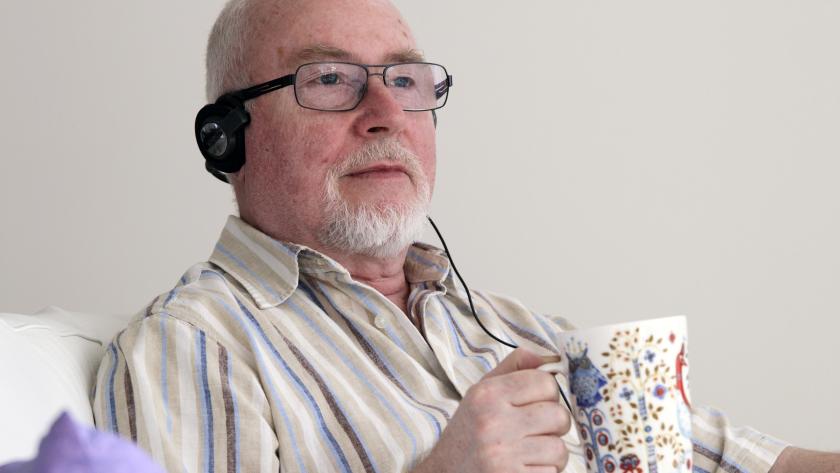 Ældre mand lytter til en lydbog