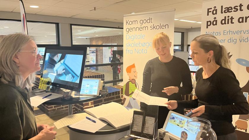 Notas stand. 2 personer fortæller, mens en 3. person lytter opmærksomt