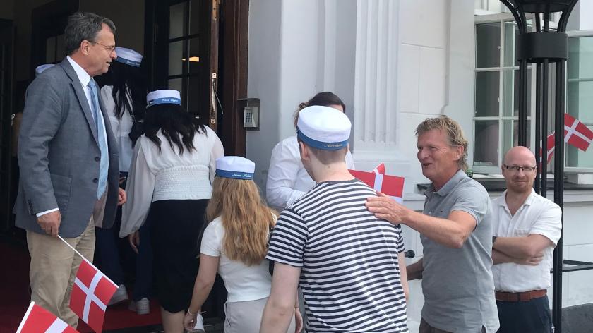 glade studenter entrerer rådhuset. mennesker smiler og har flag.