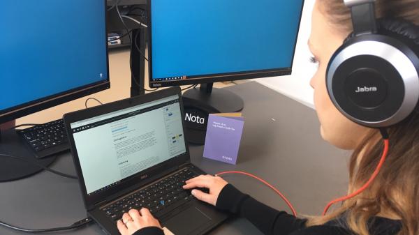 Person ved pc med høretelefoner